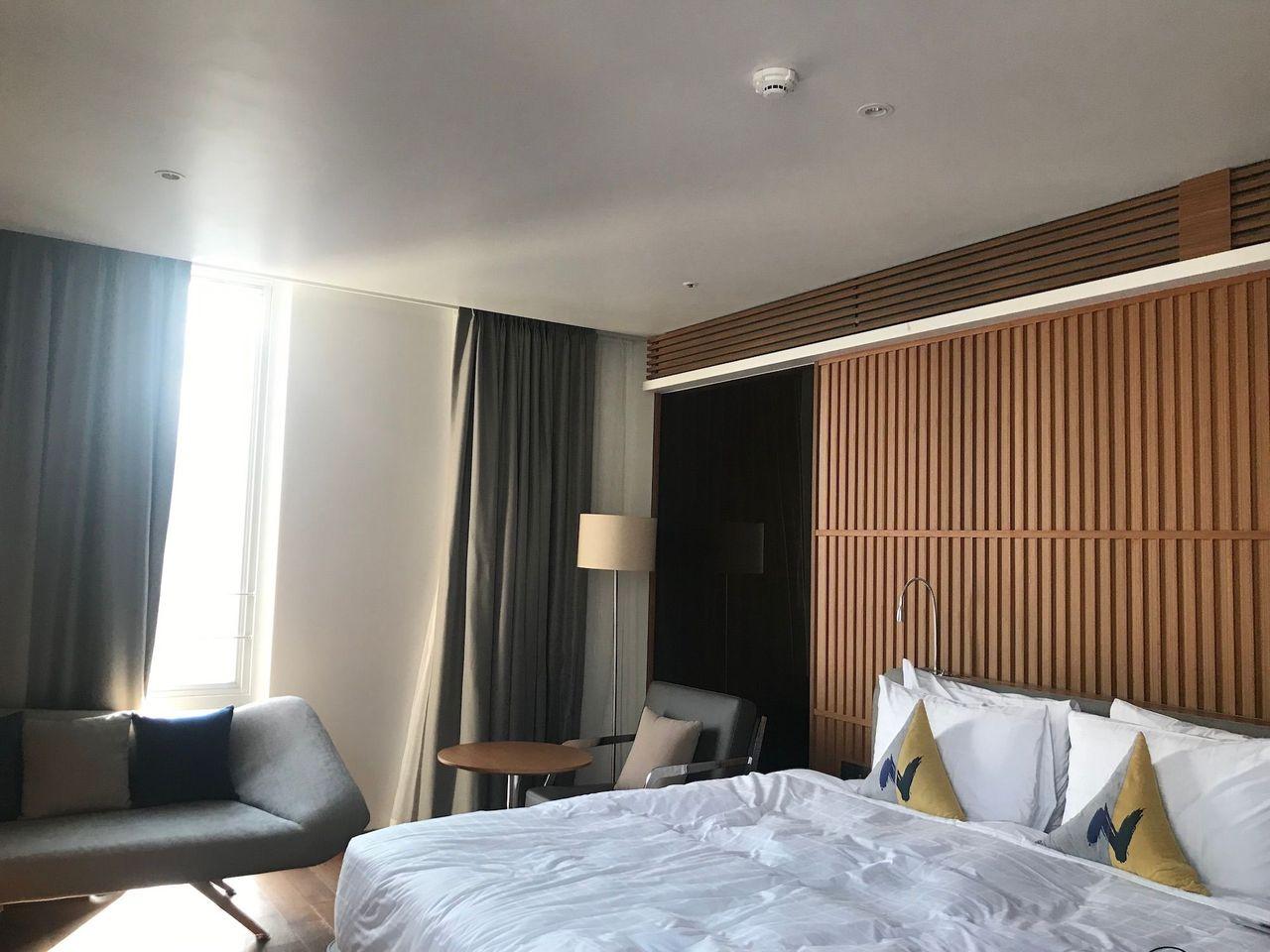 Luxury room with a comfortable bed, couch, and floor-to-ceiling windows at Dongdaemun Novotel Ambassador Hotel.